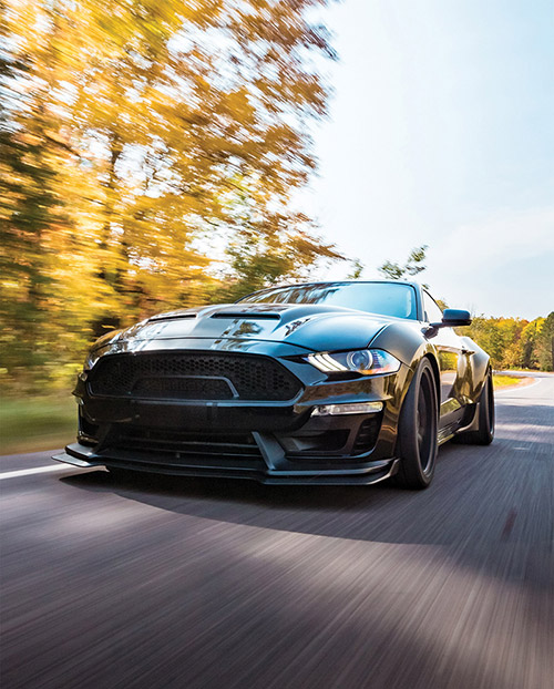 high performance Mustang driving through woods, running AMSOIL motor oil.